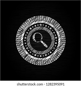 magnifying glass icon inside chalkboard emblem written on a blackboard