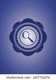 magnifying glass icon inside emblem with jean background