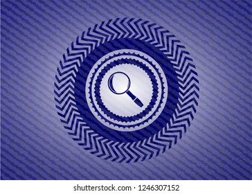 magnifying glass icon inside jean or denim emblem or badge background