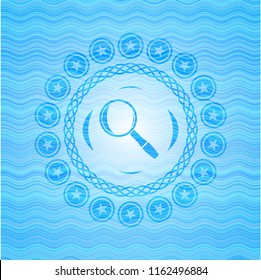 magnifying glass icon inside light blue water wave style emblem.