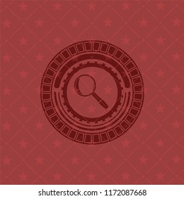 magnifying glass icon inside red emblem