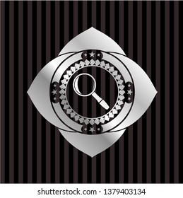 magnifying glass icon inside silver badge or emblem