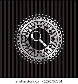 magnifying glass icon inside silvery emblem