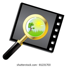 A magnifying glass is located on a photographic negative, with a green lawn and the sun