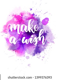 Make a wish - handwritten modern calligraphy lettering text on abstract watercolor paint splash background. Inspirational text.