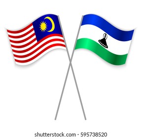 Malaysian and Basotho crossed flags. Malaysia combined with Lesotho isolated on white. Language learning, international business or travel concept.
