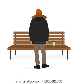 A male character stands with his back near a bench and a beer can stands on the bench