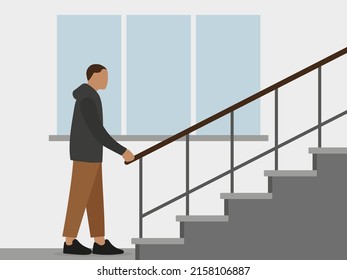 A male character stands near the stairs and holds on to the railing against the background of a wall with a window