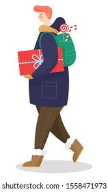 Male character wearing warm clothes and carrying presents in box. Isolated personage with gift decorated with ribbon and wrapping paper. Traditional xmas candy behind back of boy. Vector in flat