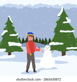 A male child walks in the forest and playing with the snow. Happy boy in warm clothes is standing against the background of a snowy christmas tree. Male character is sculpting a snowman outside