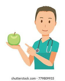 A male doctor wearing a green scrub has an apple