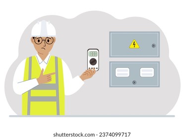 Un ingeniero eléctrico macho sostiene un multímetro digital en la mano y se para al lado de un gabinete eléctrico.