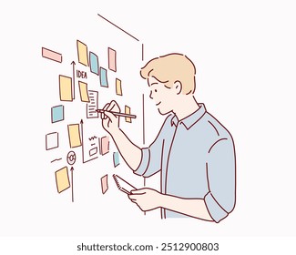  male employee write on colorful sticky notes develop business project in office, concentrated biracial man worker brainstorm engaged in creative thinking make startup plan.