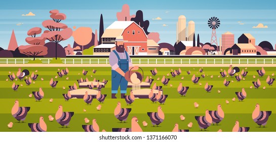 male farmer feeding chicken and rooster free range farming breeding hed for food poultry farm concept field farmland countryside landscape flat full length horizontal