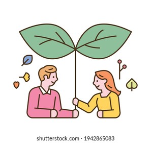 Male and female characters are using large leaves like umbrellas. flat design style minimal vector illustration.
