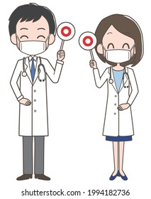 A male and female doctor wearing masks holding the correct tag.