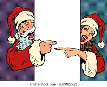 Male and female Santa Claus point to an empty poster. Christmas and New Year. Winter seasonal holiday