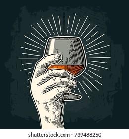 Male hand holding glass brandy with ray. Vintage vector color and monochrome engraving illustration for web, poster, invitation to party. Isolated on dark background.