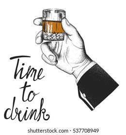 Male hand holding a glass of whiskey