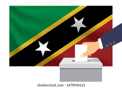 Male hand puts down a white sheet of paper with a mark as a symbol of a ballot paper against the background of the Saint Kitts flag. Saint Kitts the symbol of elections.