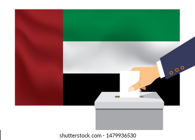 Male hand puts down a white sheet of paper with a mark as a symbol of a ballot paper against the background of the UAE flag. UAE the symbol of elections.