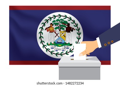 Male hand puts down a white sheet of paper with a mark as a symbol of a ballot paper against the background of the Belize flag. Belize the symbol of elections.