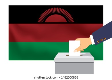 Male hand puts down a white sheet of paper with a mark as a symbol of a ballot paper against the background of the Malawi flag. Malawi the symbol of elections.