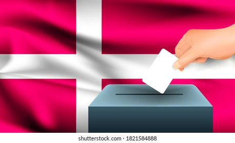 Male hand puts down a white sheet of paper with a mark as a symbol of a ballot paper against the background of the Denmark flag. Denmark the symbol of elections