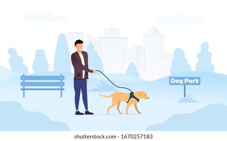 Male owner walking his dog in a harness in special dog park place in the city