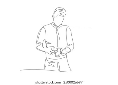 Male photographer looks at the photos he has taken. World photography day concept one-line drawing