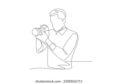 Male photographer preparing to take a photo facing sideways. World photography day concept one-line drawing