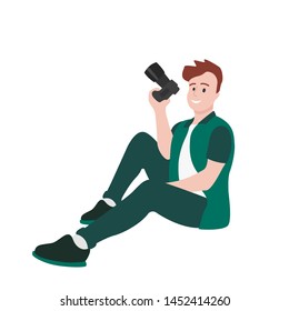 male photographer sits with a camera in his hand