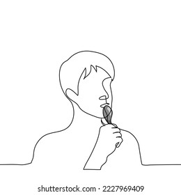 male portrait with spoon in mouth - one line drawing vector. concept hunger, lick a spoon