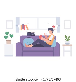 A male reading a book and drinking a cup of hot coffee on couch with his cat in a home