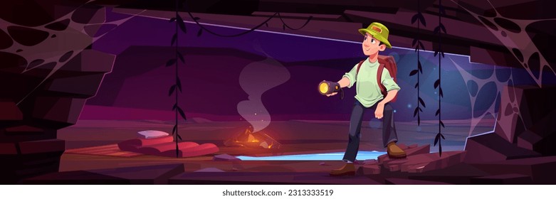 Male traveler standing in cave with flashlight. Vector cartoon illustration of happy man with backpack exploring mountain grotto, underground lake, lianas on wall, campfire and sleeping bag on ground