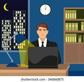 Male working late on her laptop. Surfing the internet, or perhaps working late with . Moonlit city scene can be seen in background through the window.