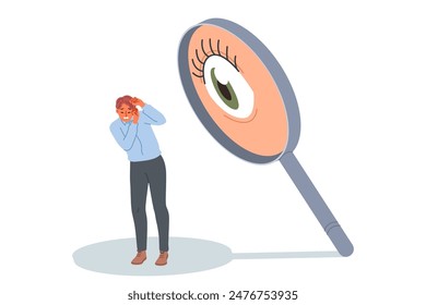 Man is afraid of surveillance and pressure from giant eye in magnifying glass, causing stress and discomfort. Concept of pressure on employee from annoying boss who does not trust company staff