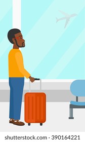 Man at airport with suitcase.