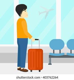 Man at airport with suitcase.