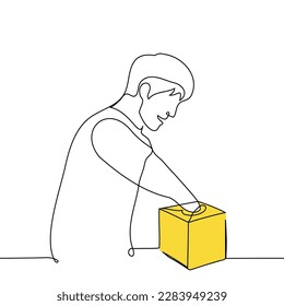  man with anticipation or joy put his hand into a small yellow box with a narrow opening - one line drawing vector. concept surprise, receiving a gift