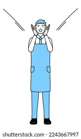 A man in an apron calling out and his hand over his mouth 