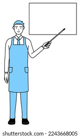 A man in an apron pointing at a whiteboard with an indicator stick.