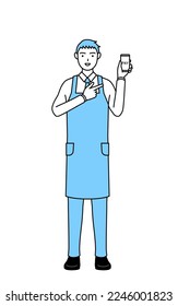 A man in an apron recommending cashless online payments on a smartphone.