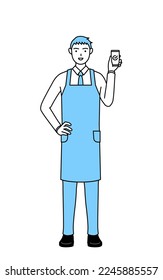 A man in an apron using a smartphone at work.