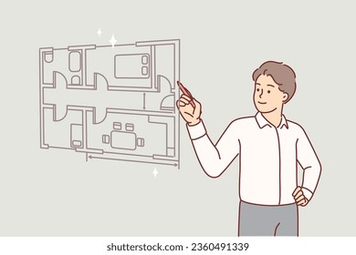 Man architect draws room plan of apartment on virtual screen, choosing place for furniture and interior items. Guy architect creates construction drawings for team of workers doing repairs in house