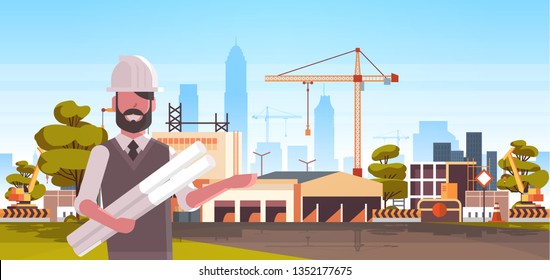 man architect in helmet holding rolled up blueprints over city construction site tower cranes building residential buildings cityscape skyline background portrait horizontal