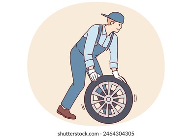 Man automobile repairman changes car wheel to new one to avoid accident or perform scheduled inspection. Employee of garage car workshop conducts vehicle maintenance or pre-sale preparation