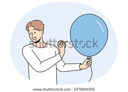 Man with balloon holds needle, wanting to make loud explosion to cheer people around. Happy guy dressed in casual style with blue balloon in hands makes prank to scare or amuse friends.