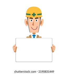 A man in beige work clothes and a helmet holding a whiteboard