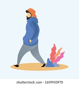 A man in a blue jacket is walking in the afternoon